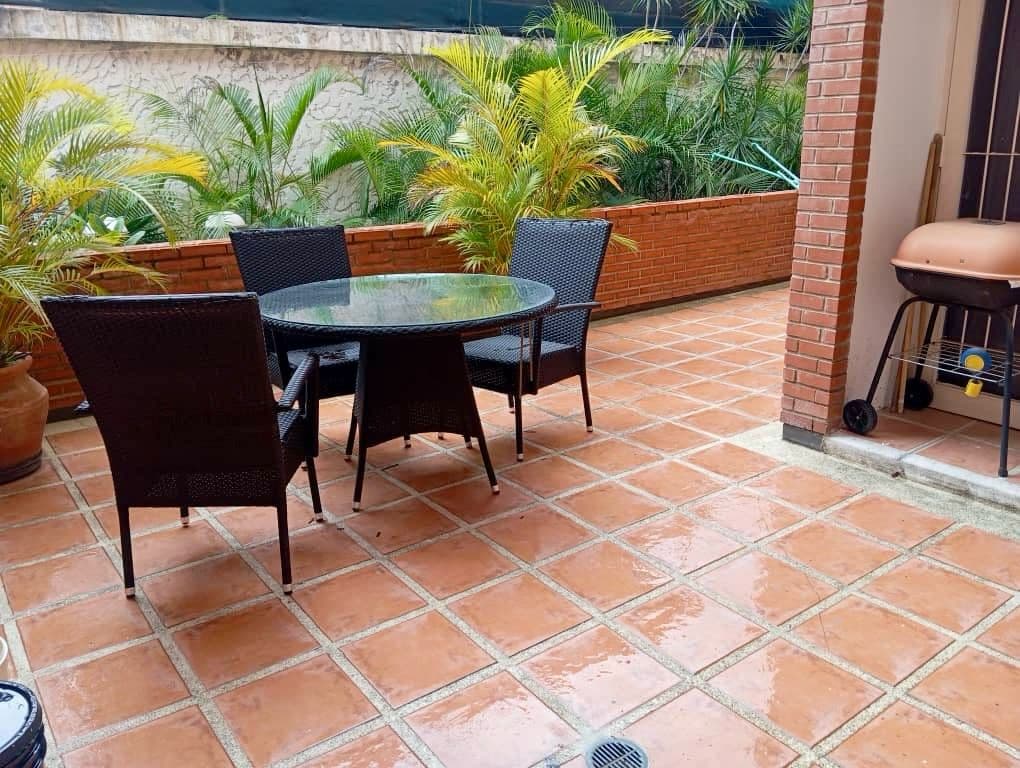 Terraza con mesa exterior y parrillera