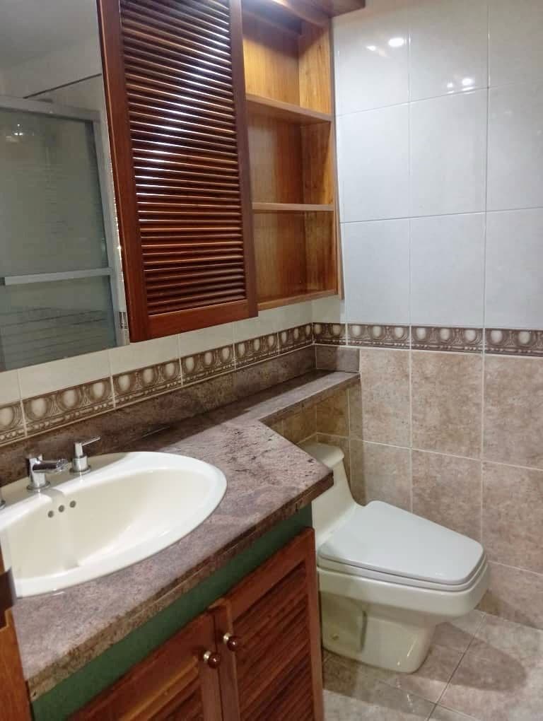 Baño con lavamanos empotrado y gabinete de madera