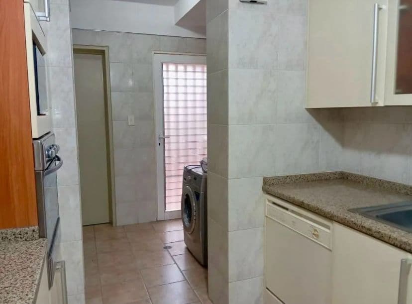 Área de lavandero con lavadora, junto a la cocina