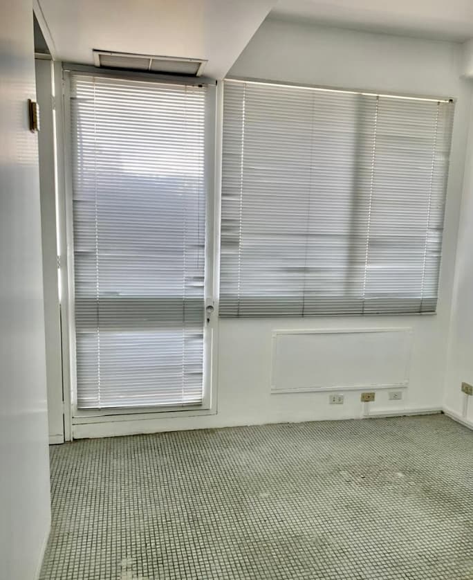 Oficina con ventanal y puerta de salida al balcón